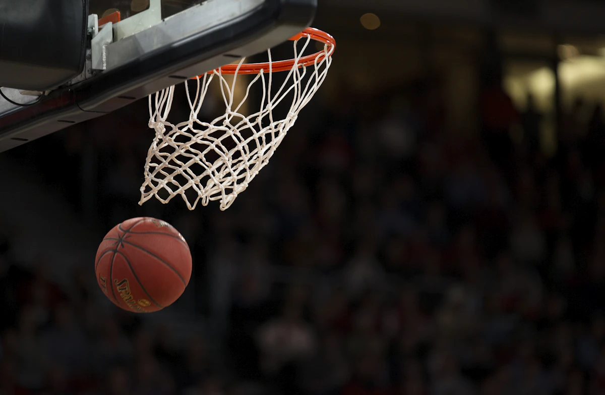 Basketball going through hoop under stadium lights