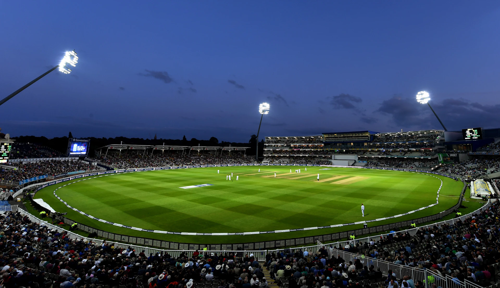 dramatic wide angle shot of a professional sports stadium at night under bright stadium lights
